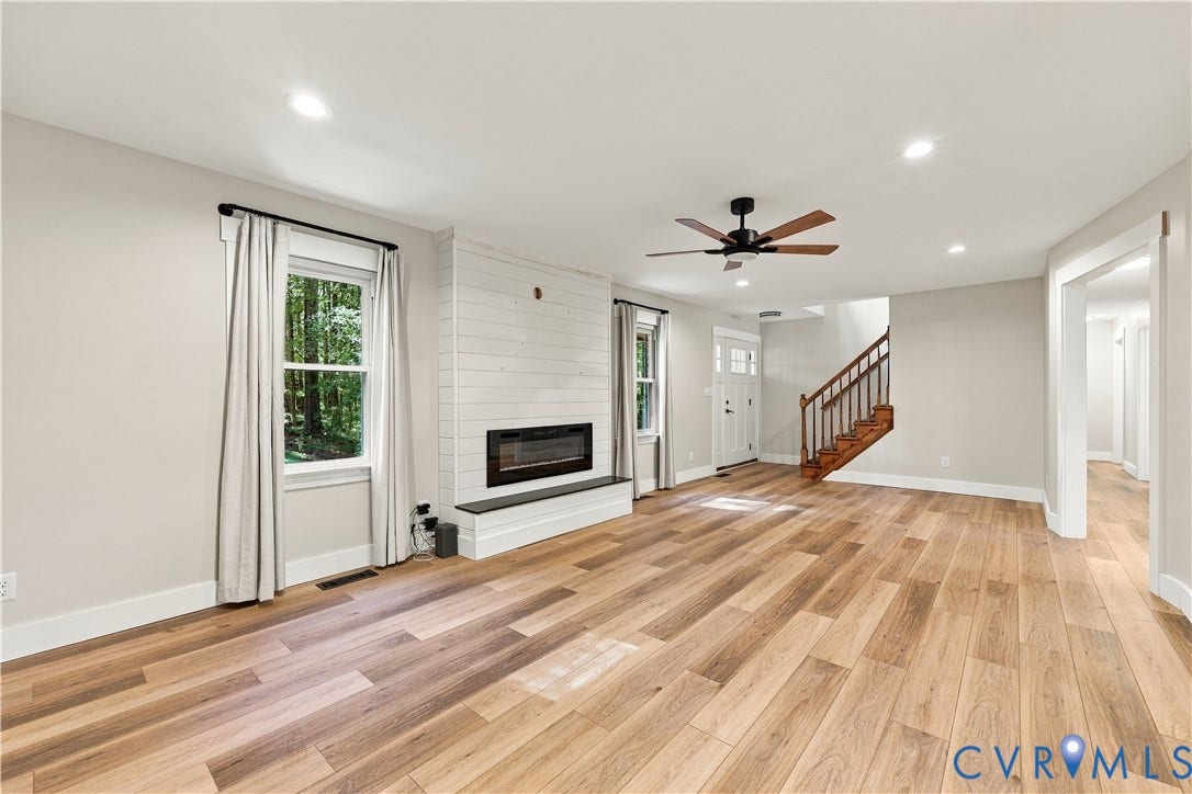 17 River Walk, Cumberland, VA 23027 Spacious living area featuring wood-finish flooring, recessed lighting, and a modern electric fireplace with a shiplap surround
