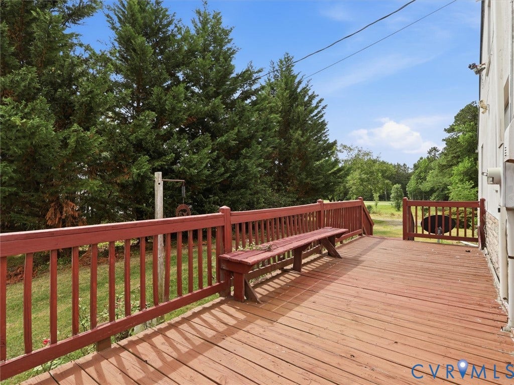 21600 Patrick Henry Highway, Amelia, VA 23083 Expansive wooden deck with a built-in bench, red-stained railings, and mature evergreen trees