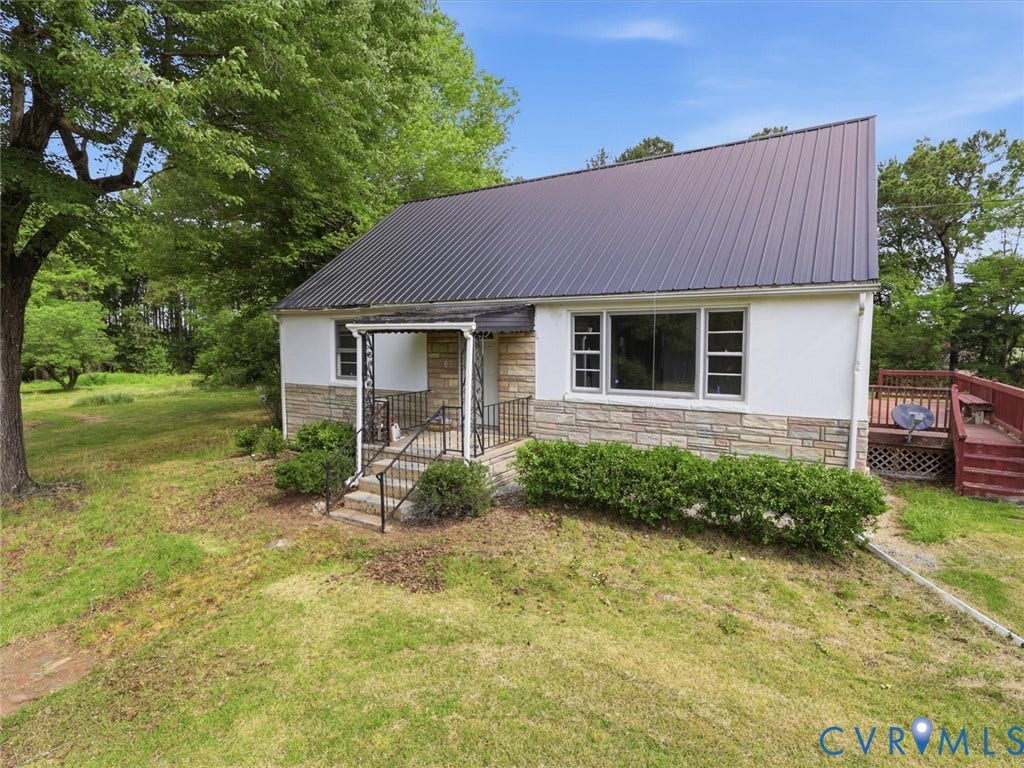 21600 Patrick Henry Highway, Amelia, VA 23083 Exterior featuring a metal roof, stone veneer, stucco siding, a covered entry with wrought iron railings, and a wooden deck