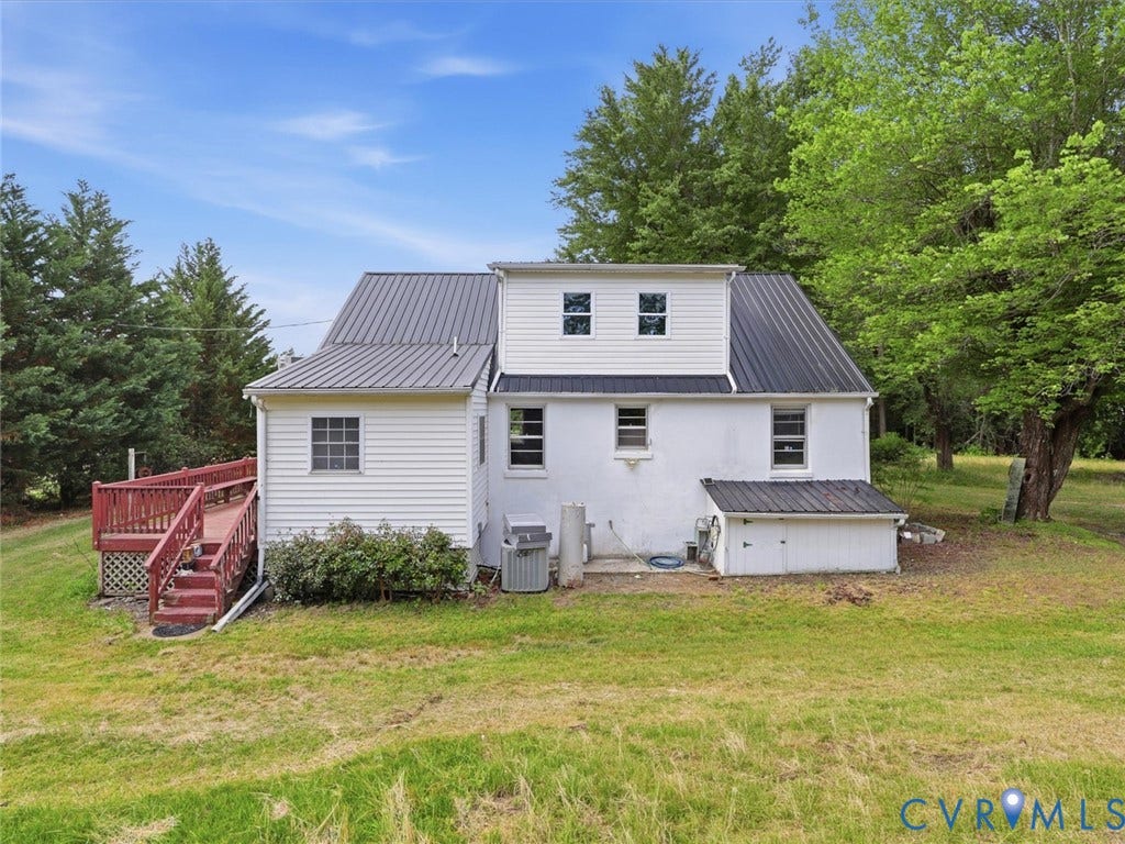 21600 Patrick Henry Highway, Amelia, VA 23083 White siding exterior with a dark metal roof, featuring a red wood deck with a ramp