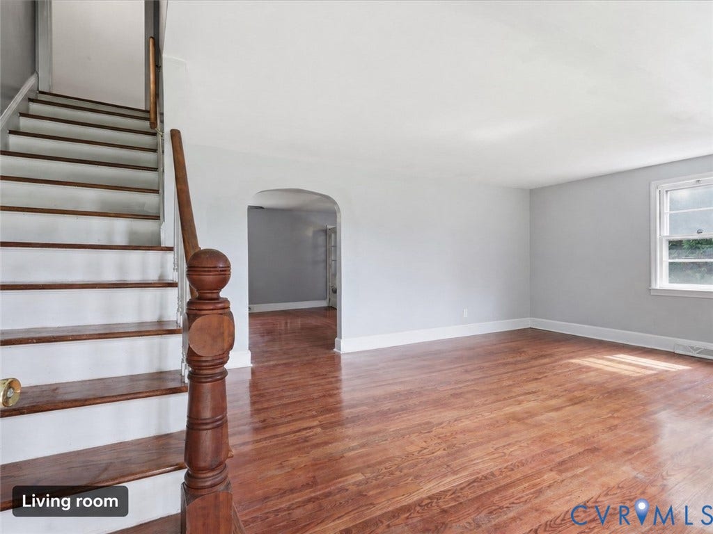 21600 Patrick Henry Highway, Amelia, VA 23083 Hardwood flooring, painted walls, white trim, staircase with wood newel post, and an arched entryway