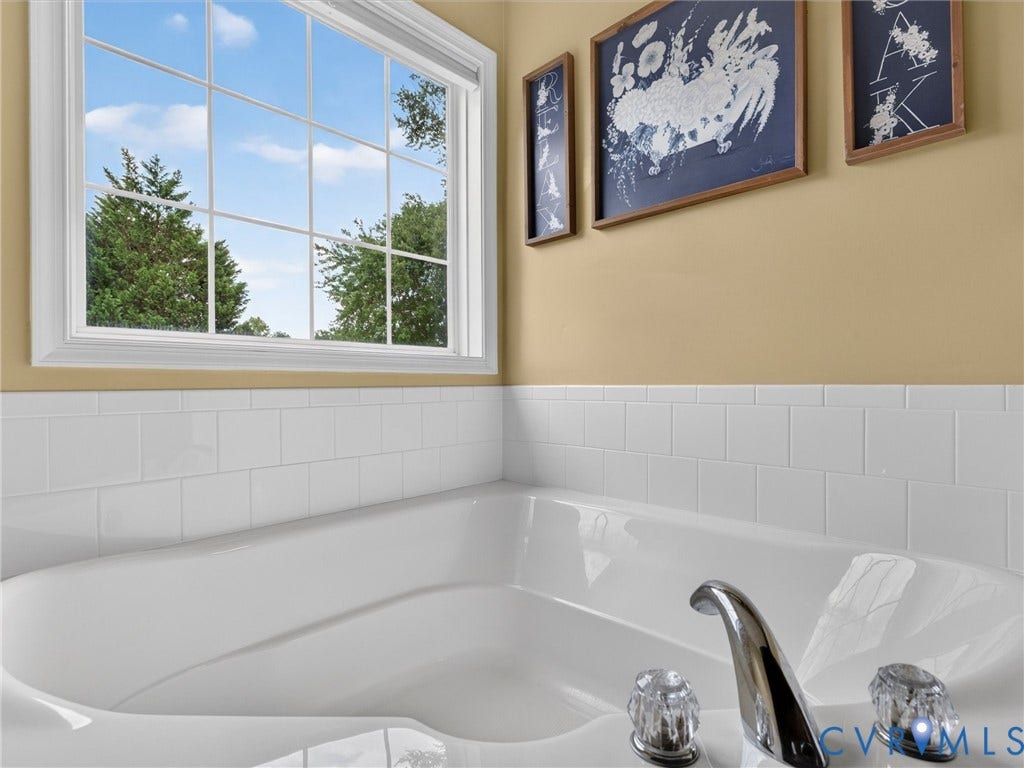 7478 Troub Lane, Elwin Place, Mechanicsville, VA 23111 Built-in soaking tub with a polished chrome faucet, clear acrylic handles, and surrounding subway tile