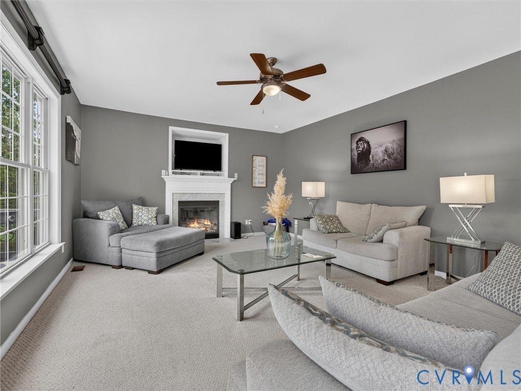 7478 Troub Lane, Elwin Place, Mechanicsville, VA 23111 Spacious living area featuring a fireplace with a white mantel, ceiling fan, and carpeted flooring