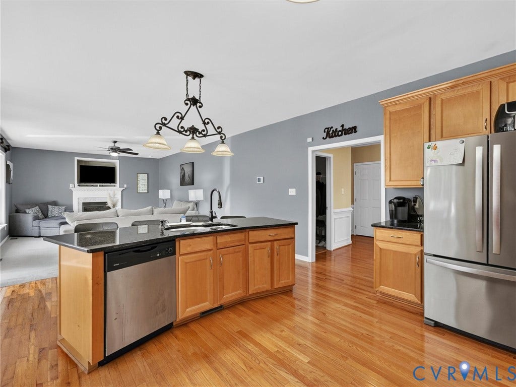 7478 Troub Lane, Elwin Place, Mechanicsville, VA 23111 Kitchen island with dark countertop, wood-finish cabinetry, stainless steel dishwasher, and a decorative pendant light fixture