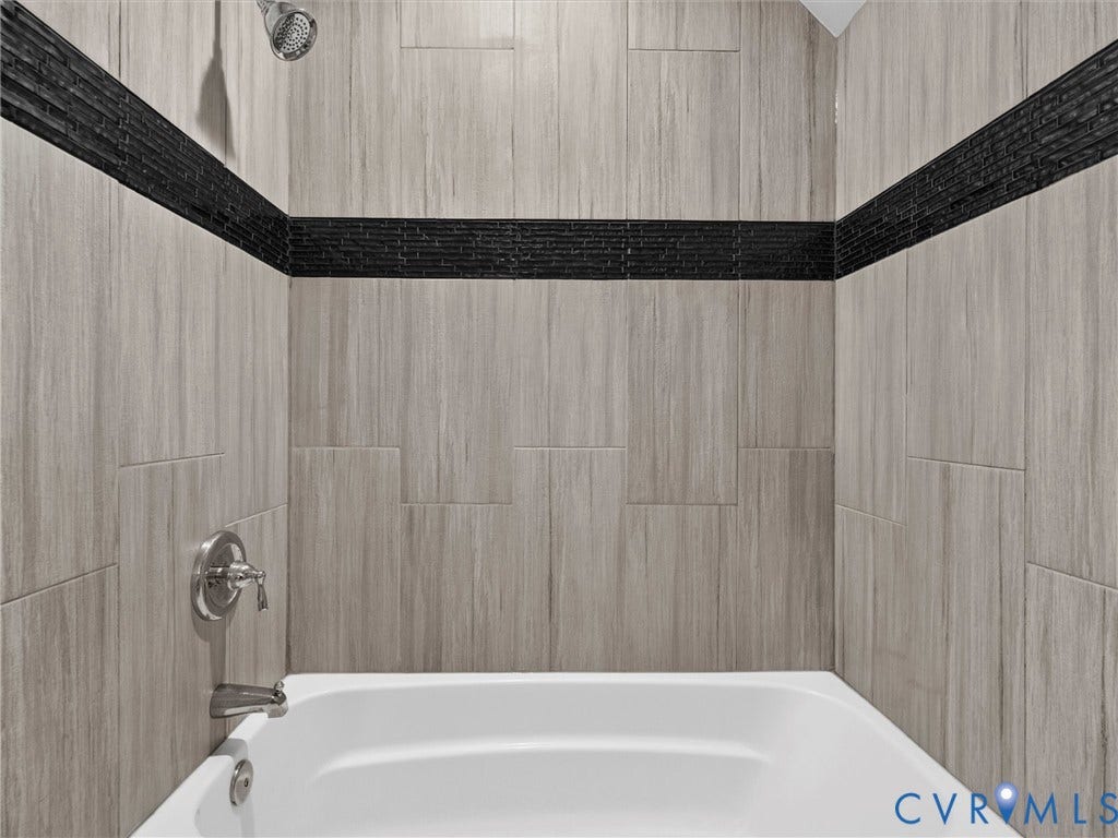 7478 Troub Lane, Elwin Place, Mechanicsville, VA 23111 Bathtub with light-toned wall tile, black accent tile band, and polished chrome fixtures