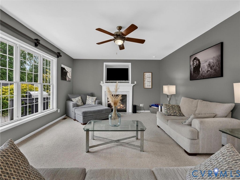 7478 Troub Lane, Elwin Place, Mechanicsville, VA 23111 Neutral-toned carpet flooring, a fireplace with a white mantel, and a ceiling fan with wood-finish blades