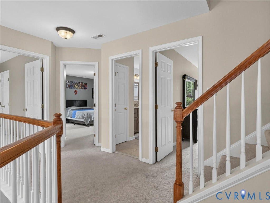7478 Troub Lane, Elwin Place, Mechanicsville, VA 23111 Carpeted hallway with multiple entryways, wood-finish handrail, and white balusters