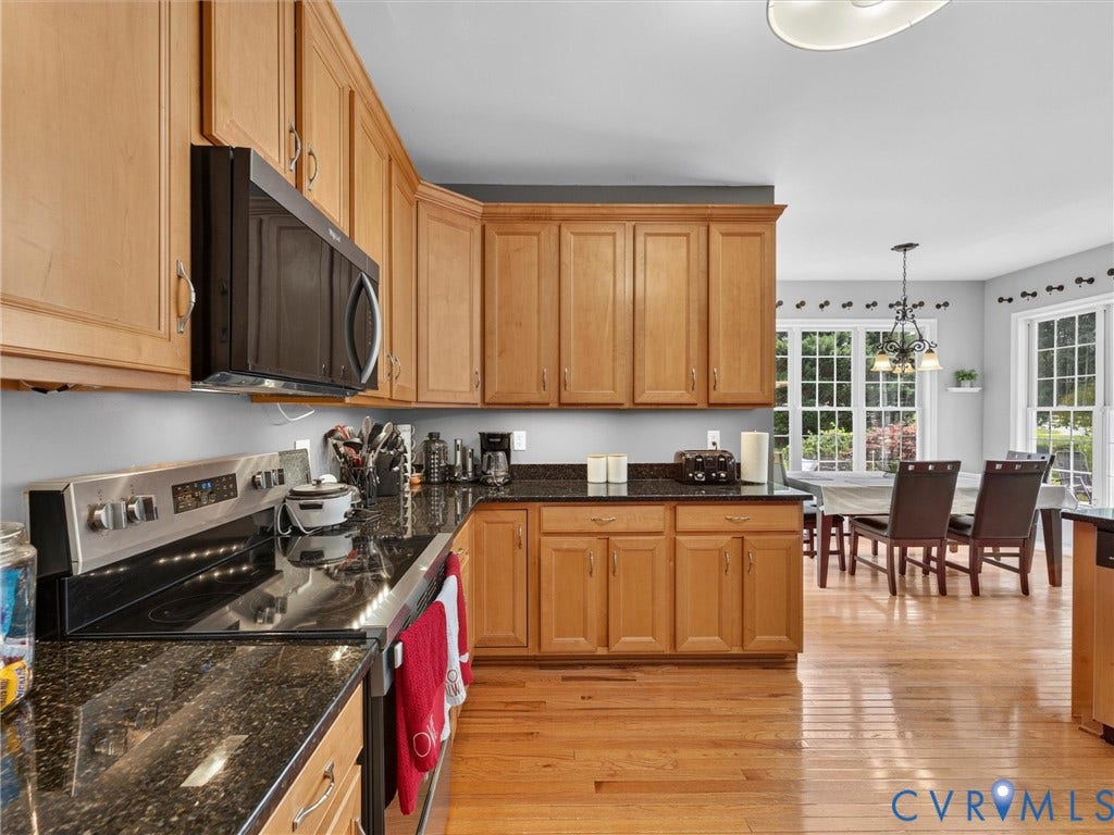 7478 Troub Lane, Elwin Place, Mechanicsville, VA 23111 Wood cabinetry, dark countertops, stainless steel range, built-in microwave, and wood-finish flooring