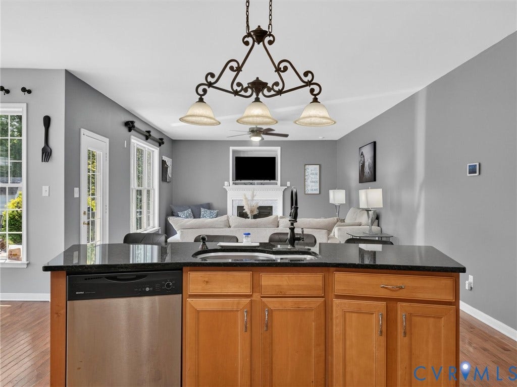 7478 Troub Lane, Elwin Place, Mechanicsville, VA 23111 Kitchen island with a built-in stainless steel dishwasher, black countertop, and wood-finish cabinetry
