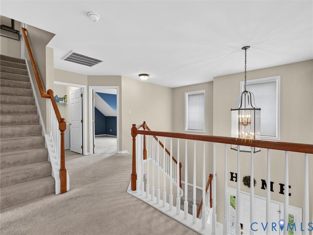 7478 Troub Lane, Elwin Place, Mechanicsville, VA 23111 Carpeted staircase with wood-finish handrails, white balusters, and a traditional chandelier