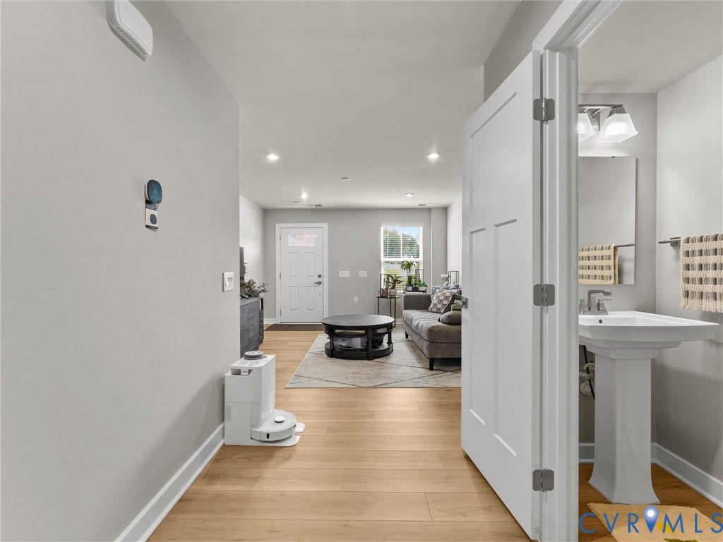 Wood-finish flooring, recessed lighting, white interior doors, pedestal sink, and chrome fixtures