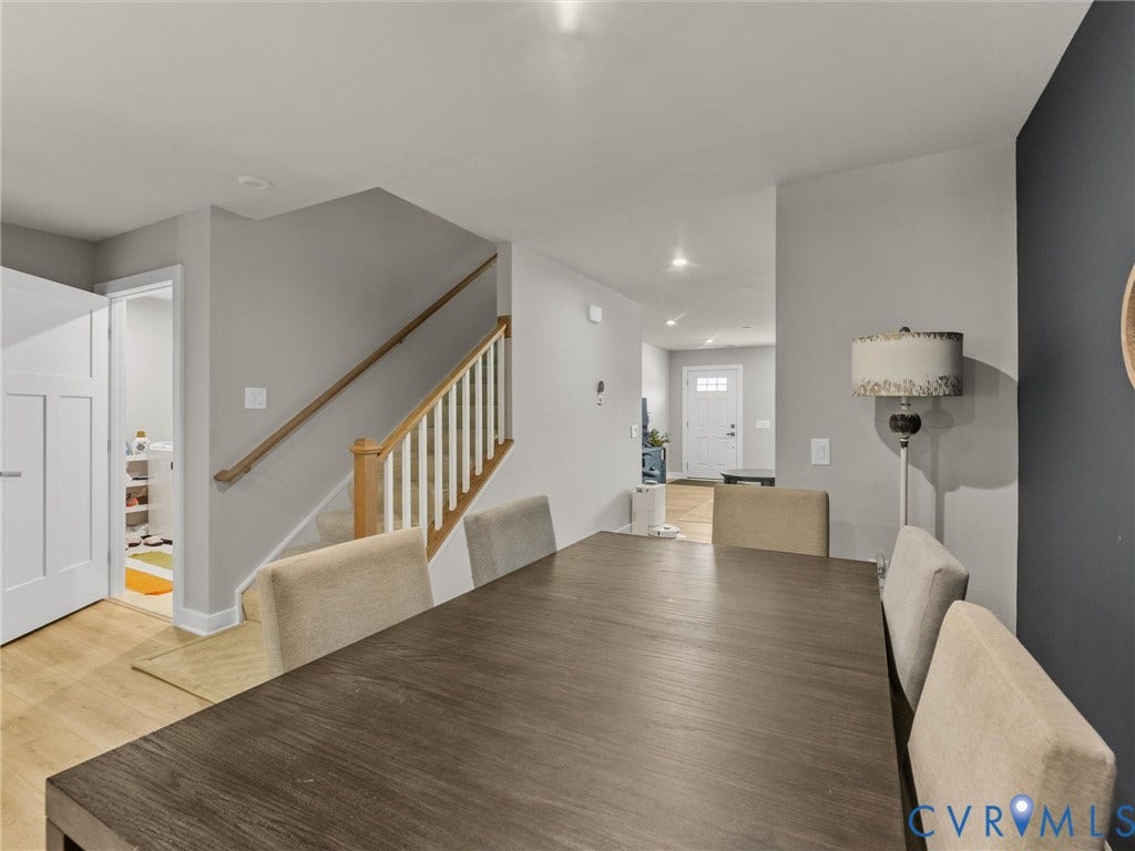 Open-concept living area with wood-finish flooring, a contemporary staircase, and recessed lighting