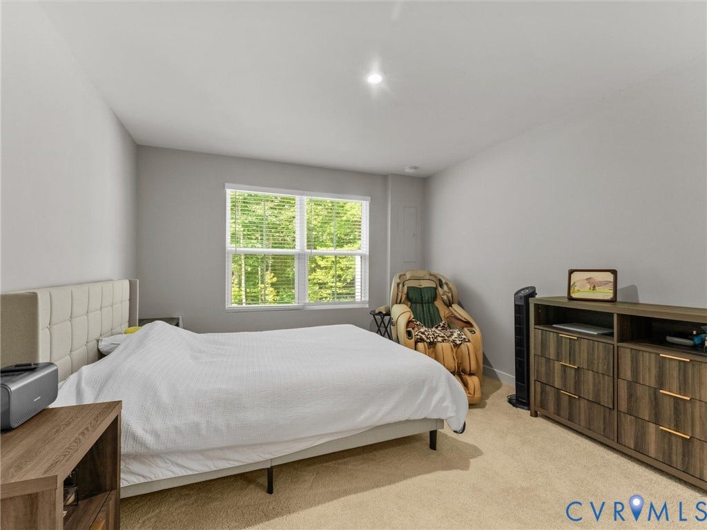 Carpeted flooring, recessed lighting, and a large window with blinds