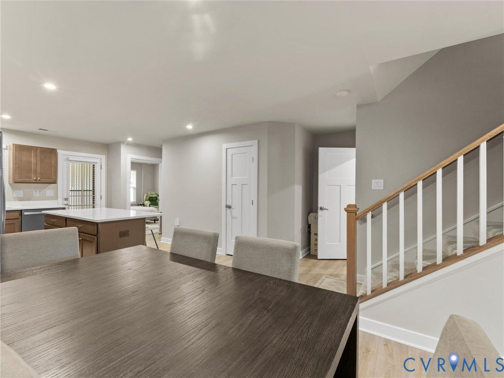 Kitchen island with a white countertop, wood-finish cabinetry, recessed lighting, and wood-finish flooring