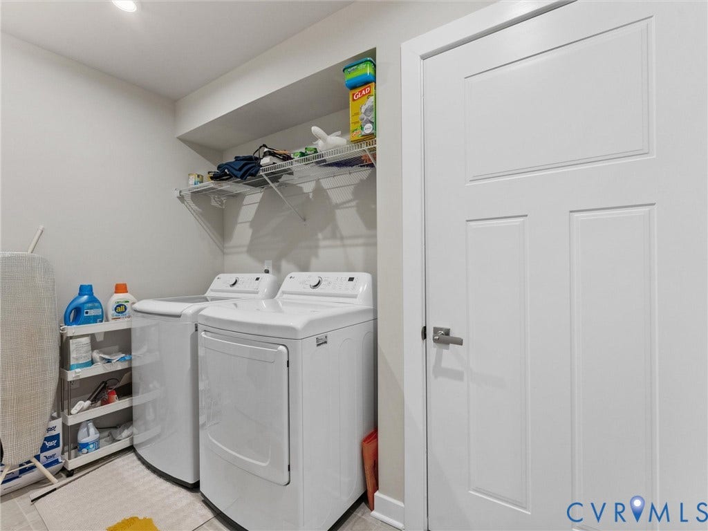 Dedicated laundry area with white appliances and an overhead storage shelf