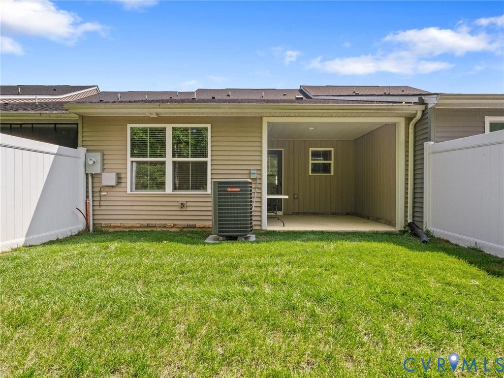 Manicured lawn, covered patio, privacy fencing, and neutral siding