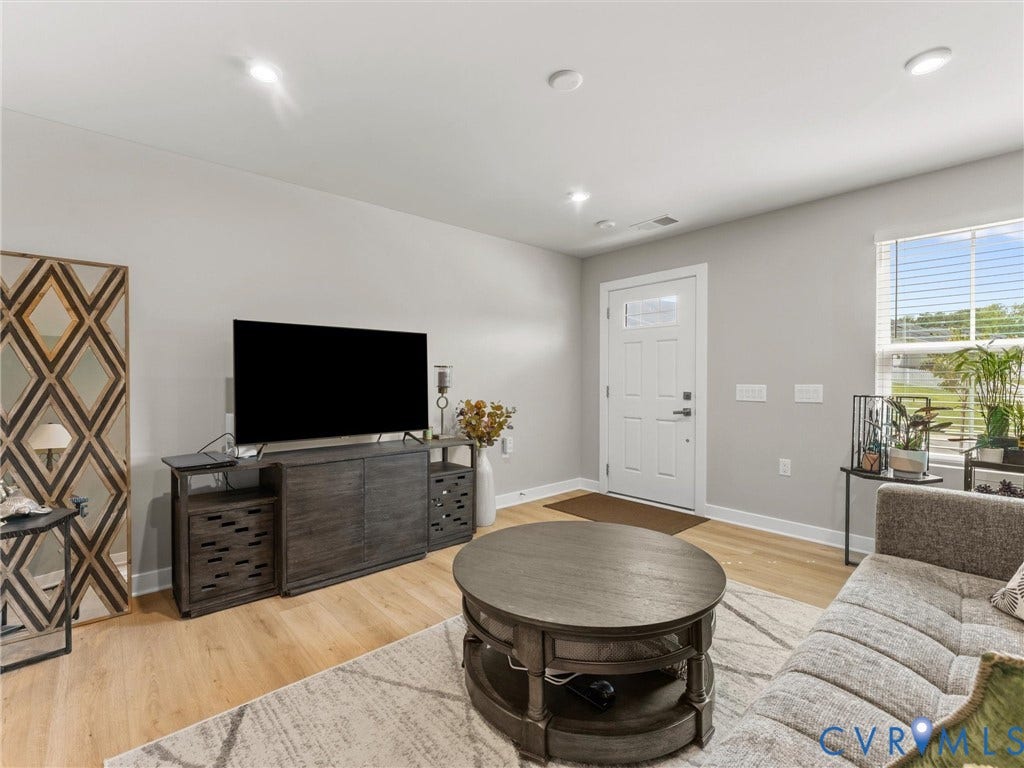 Recessed ceiling lighting, durable wood-finish flooring, and a large window with blinds