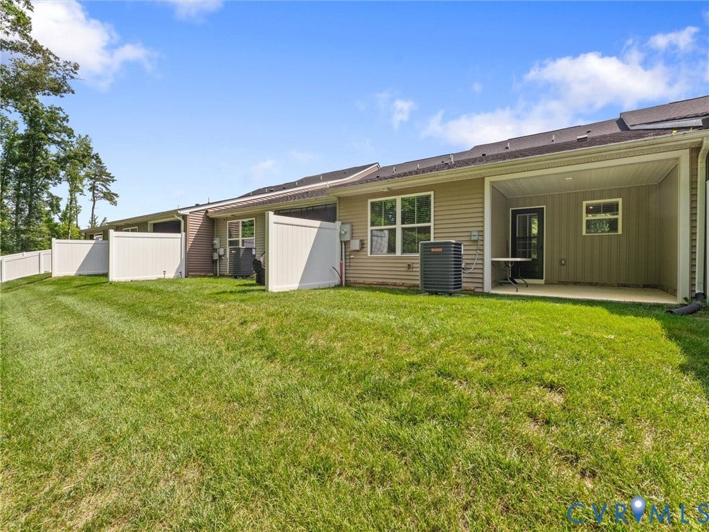 Expansive grassy area with partial privacy fencing