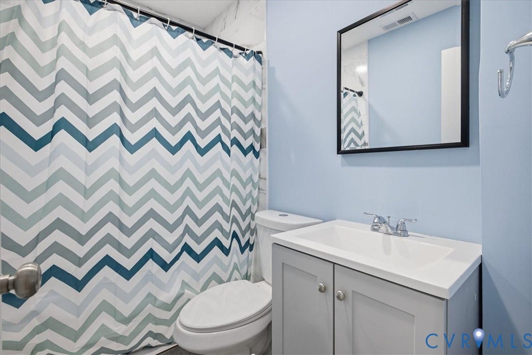 1630 W Washington Street, Petersburg, VA 23803 White countertop vanity with a chrome faucet, paired with a framed mirror