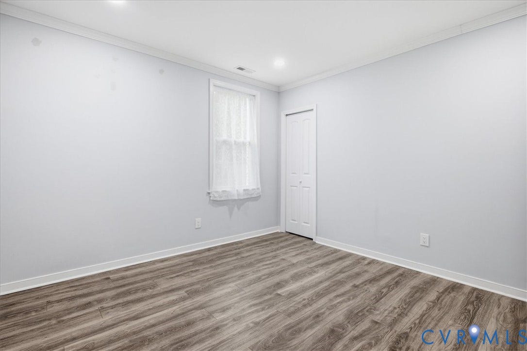 1630 W Washington Street, Petersburg, VA 23803 Wood-finish flooring with white trim, recessed lighting, and a bi-fold closet door