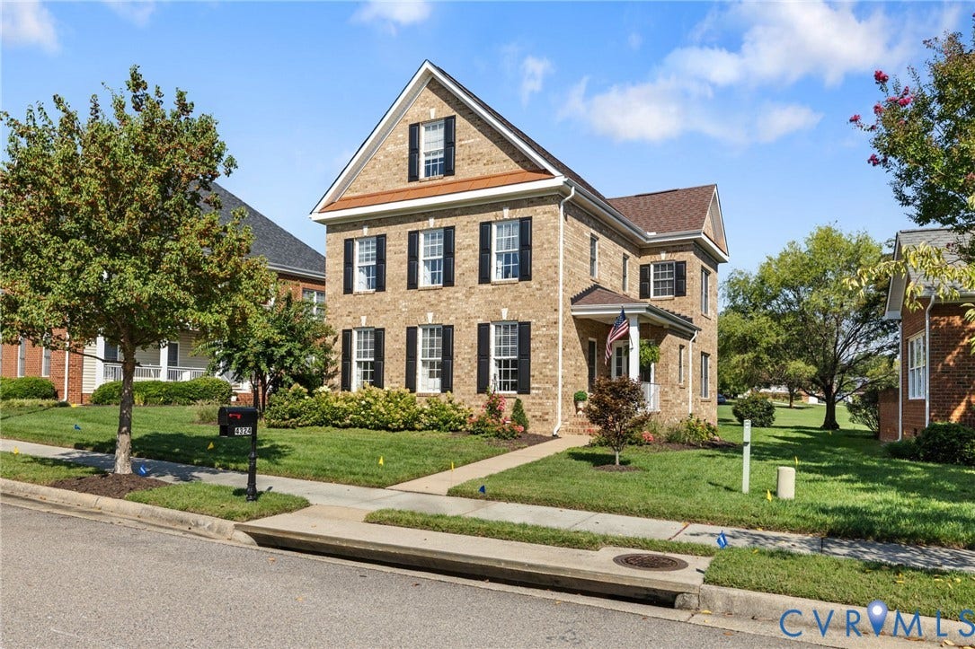 Brick exterior, multiple gables, covered front porch, established landscaping, and a manicured lawn