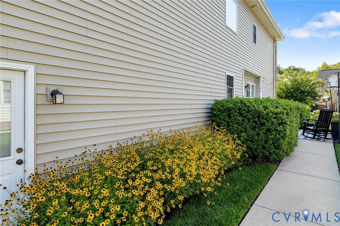 Neutral-toned siding exterior with a white door and an exterior light fixture