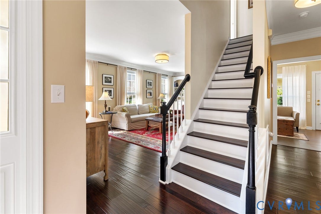 Hardwood flooring throughout, white painted risers, dark wood finish treads, dark wood finish handrails, and recessed lighting