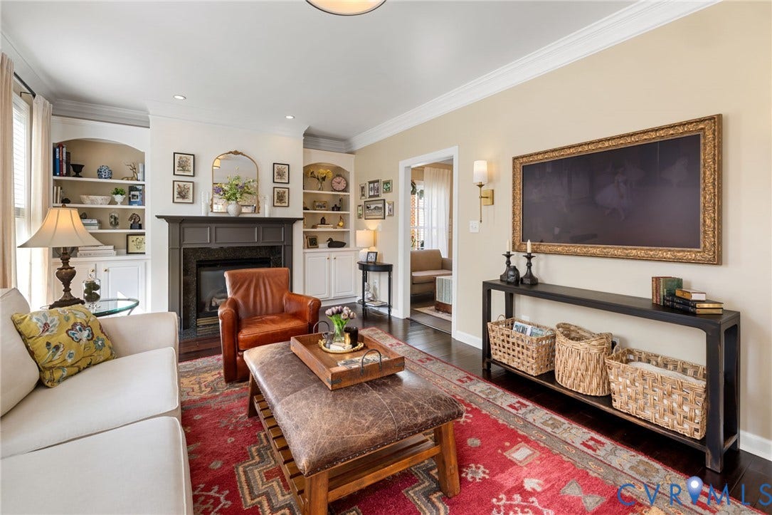Dark wood-finish flooring with a fireplace featuring a dark mantel