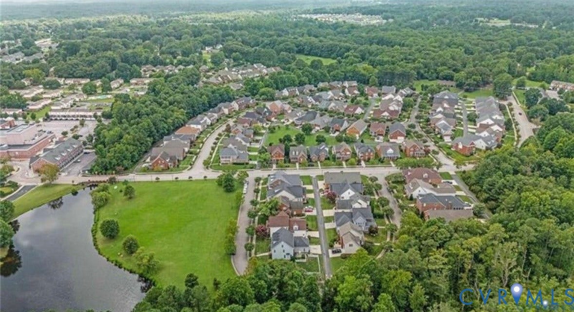 Neighborhood with residential homes, surrounding mature trees, and a body of water