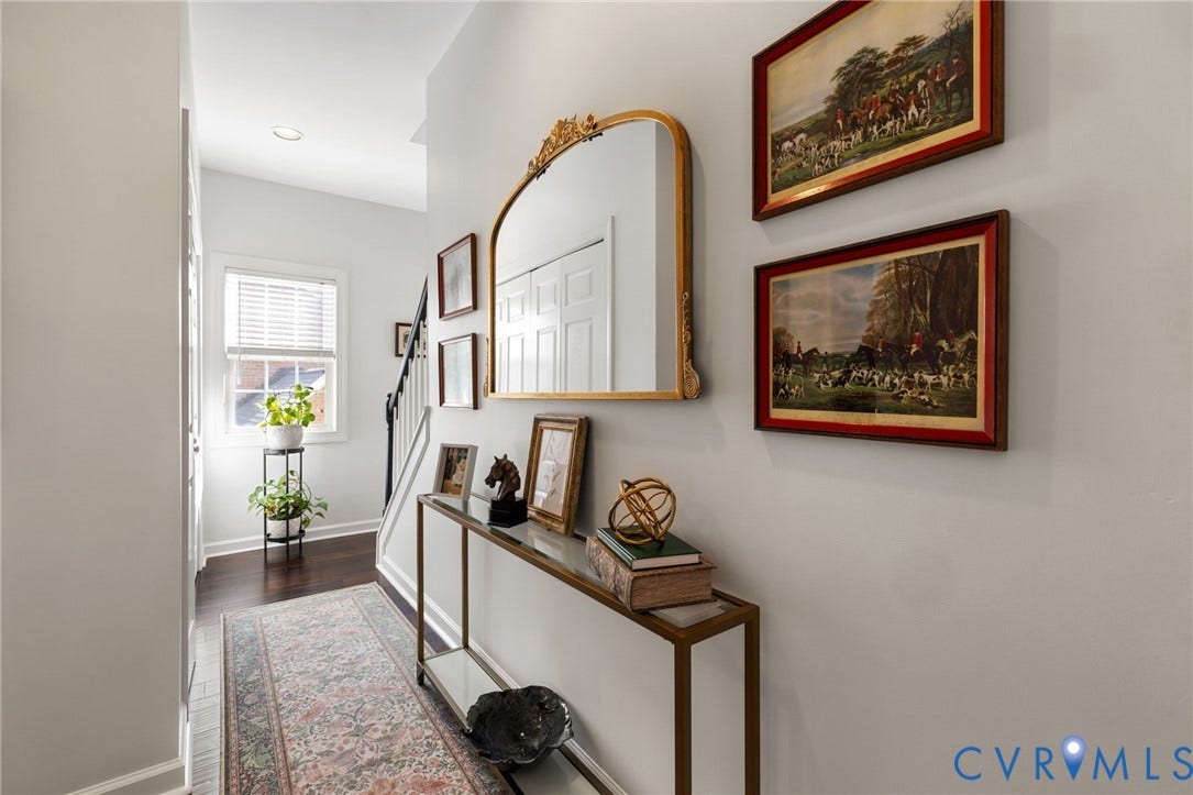 Recessed ceiling lighting, dark wood-finish flooring, white paneled doors, and a staircase with a black handrail