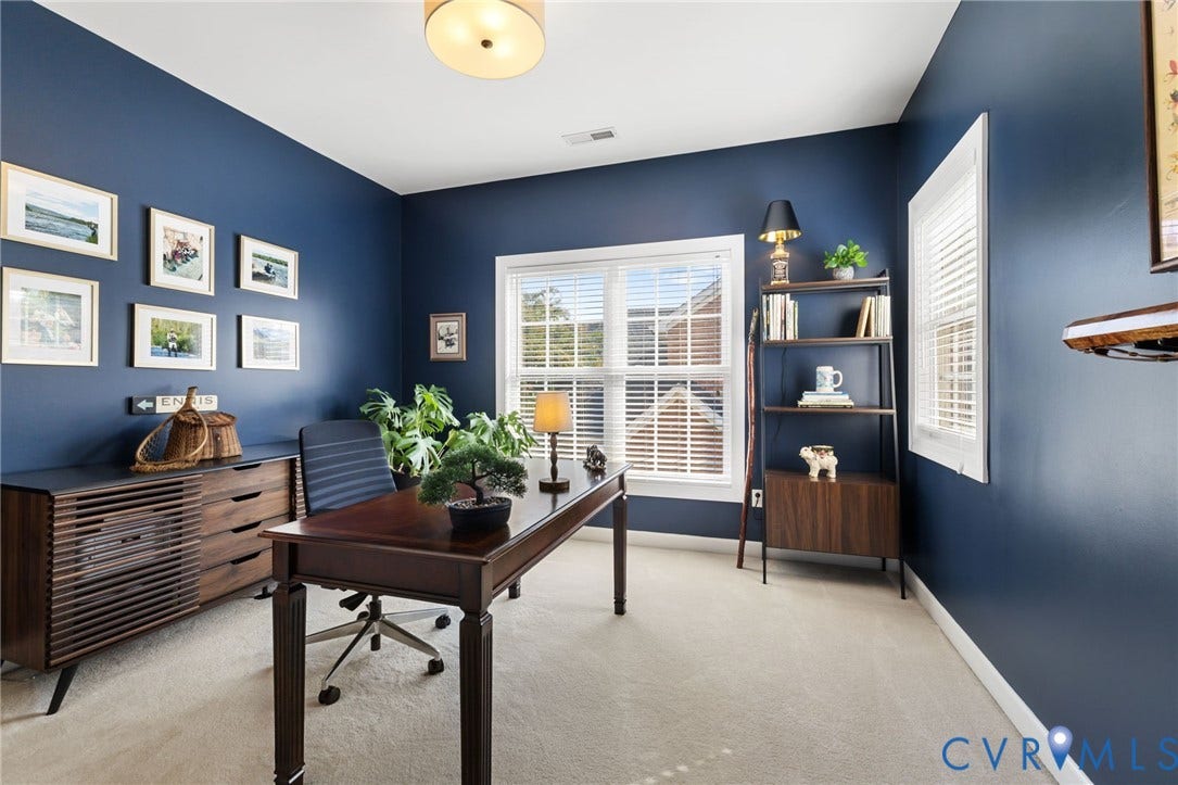 Recessed lighting, light-colored carpeting, and multiple windows providing natural illumination