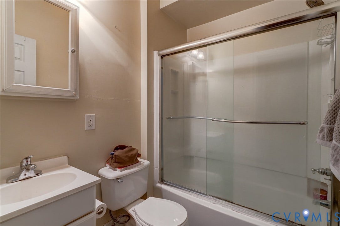 1620 W Cary Street, Fan Extenstion, Richmond, VA 23220 Vanity with an integrated sink, polished chrome faucet, framed medicine cabinet, toilet, and a shower with sliding glass doors