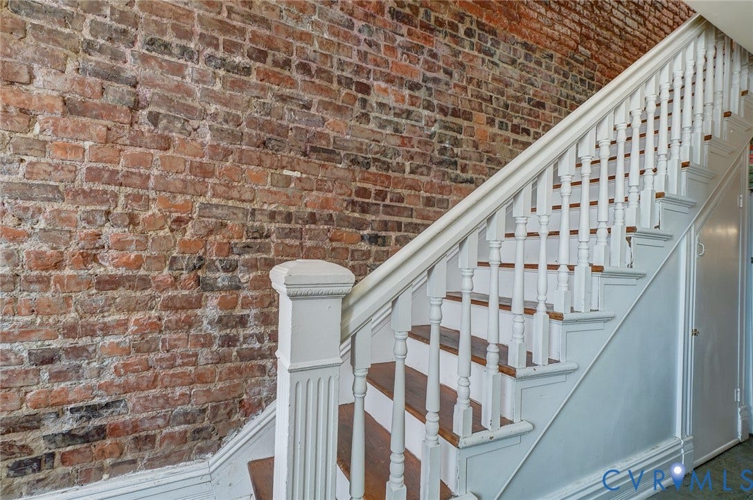 1620 W Cary Street, Fan Extenstion, Richmond, VA 23220 Exposed brick wall alongside a wood staircase with white balusters and handrail