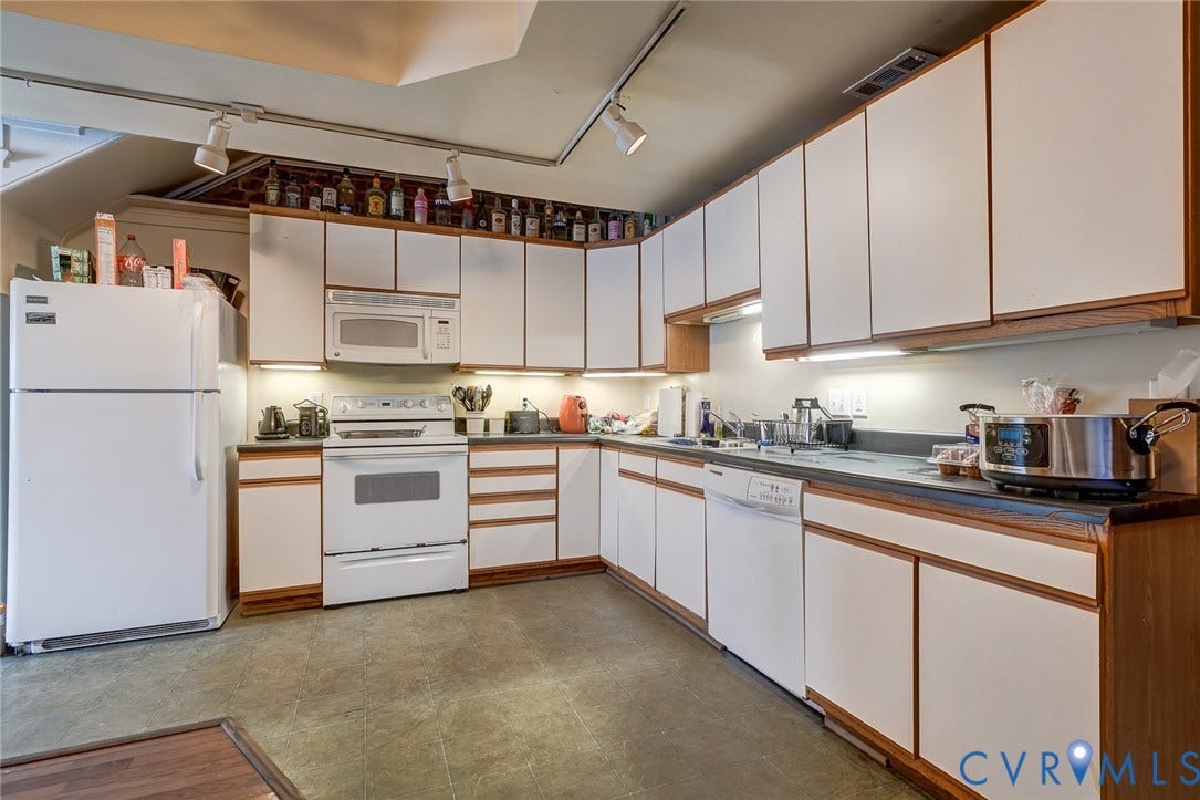 1620 W Cary Street, Fan Extenstion, Richmond, VA 23220 Kitchen featuring white cabinetry with wood trim, track lighting, an integrated microwave, and a dishwasher