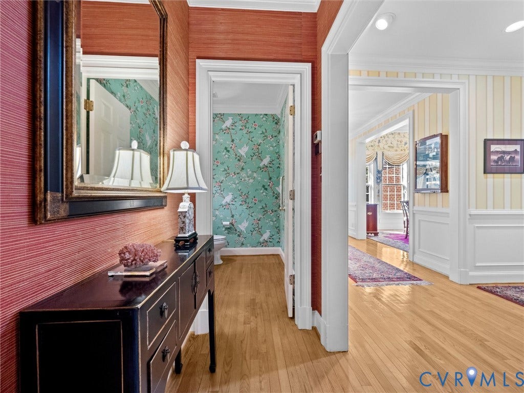 Hardwood flooring throughout, with wainscoting and crown molding details