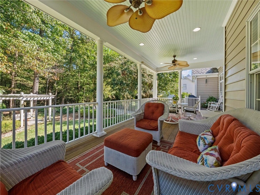 Covered outdoor porch with recessed lighting, ceiling fans, and wood-finish flooring