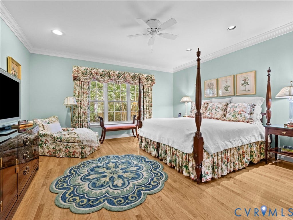Hardwood flooring, crown molding, recessed lighting, ceiling fan, and a large window