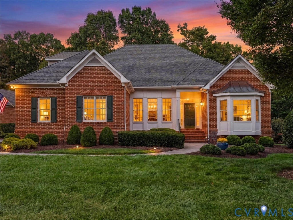Brick exterior with a gabled roofline, multiple windows, and a covered entry