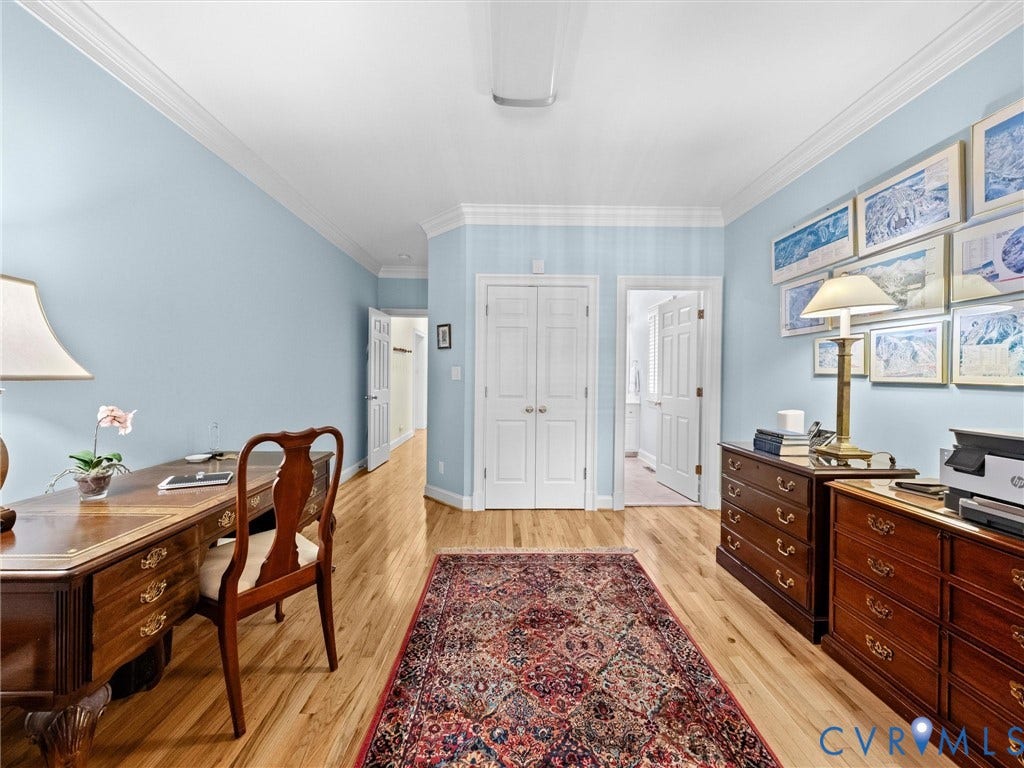 Light blue wall finish, crown molding, wood-finish flooring, white paneled doors, and ceiling lighting