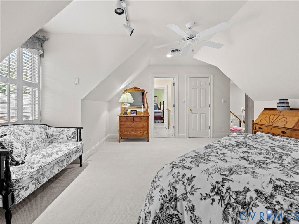 White walls, sloped ceilings, and a ceiling fan with integrated lighting