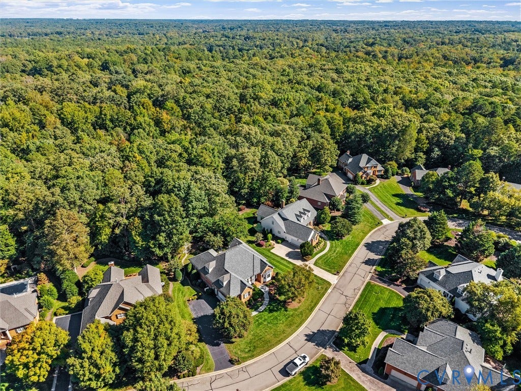 Residential neighborhood with mature trees, verdant landscaping, and paved roadways