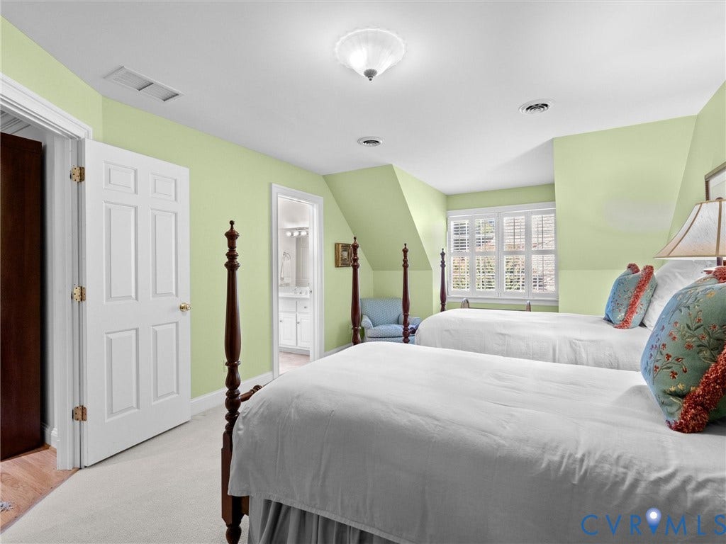 Carpeted room featuring a white paneled door, a window with white shutters, and a ceiling-mounted light fixture