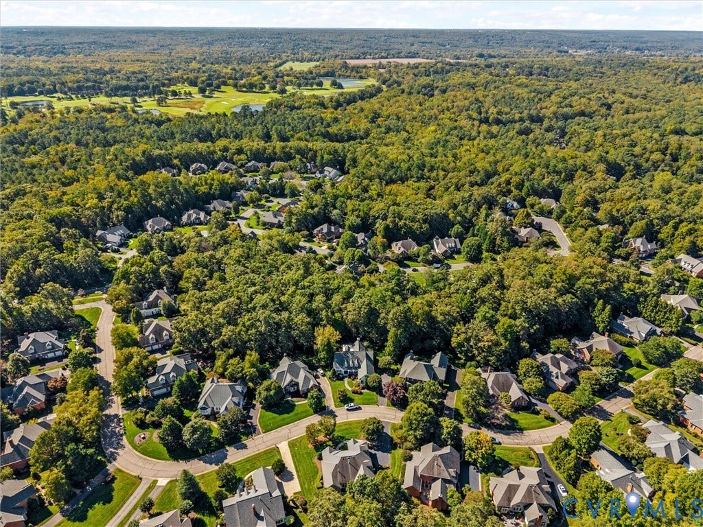Residential neighborhood with winding streets, mature trees, and a golf course