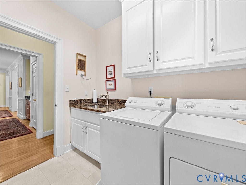 White shaker-style cabinetry, a stainless steel sink, and a speckled countertop