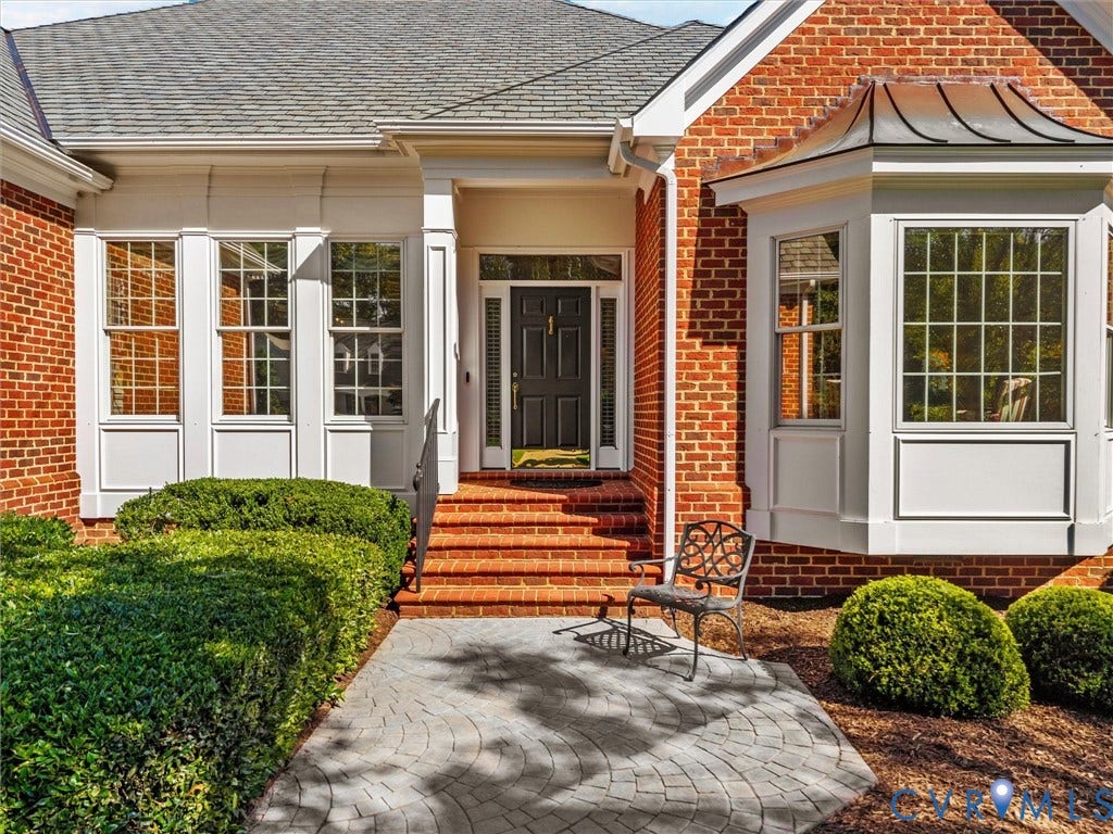 Brick exterior with white trim, bay window, and a gray shingle roof