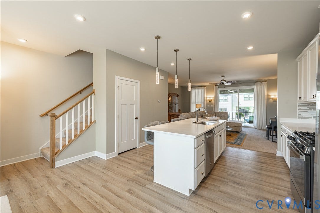14336 Altavista Boulevard, Midlothian, VA 23114 Open-concept kitchen featuring an island with a sink, stainless steel appliances, white cabinetry, and wood-finish flooring