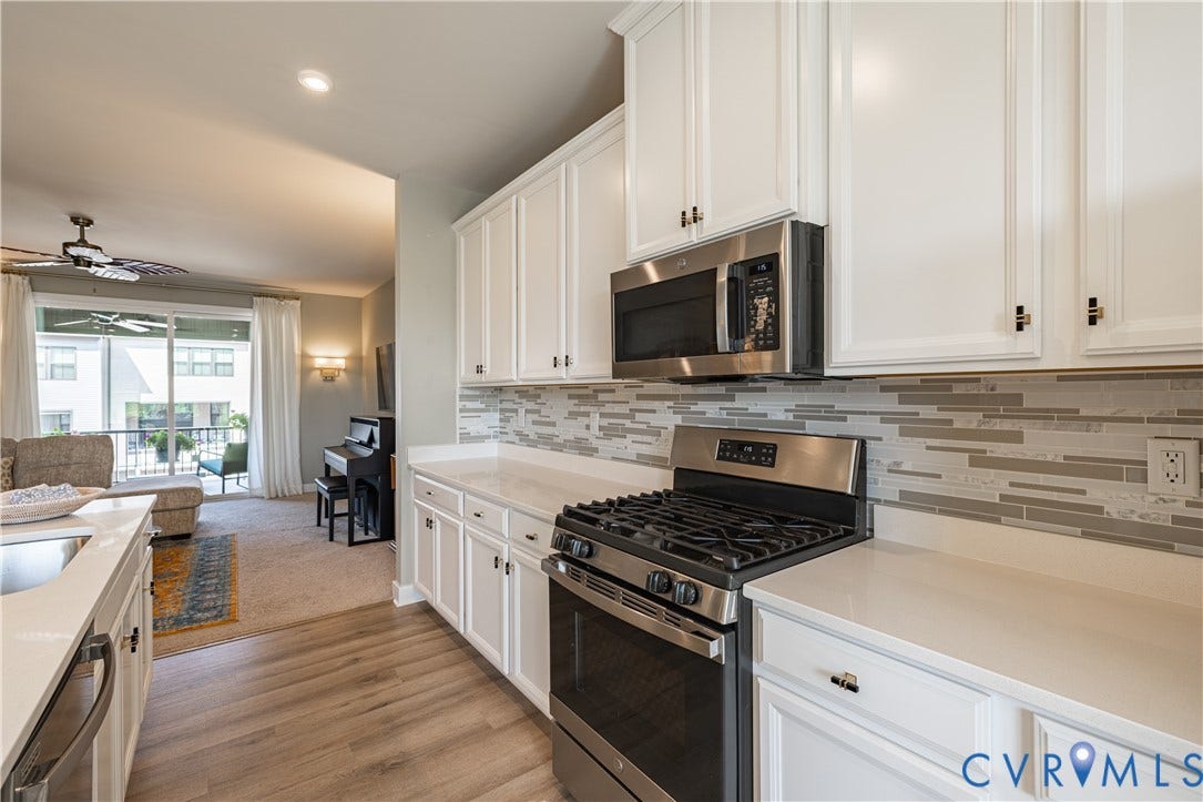 14336 Altavista Boulevard, Midlothian, VA 23114 White cabinetry, stainless steel appliances, light-toned countertops, and wood-finish flooring