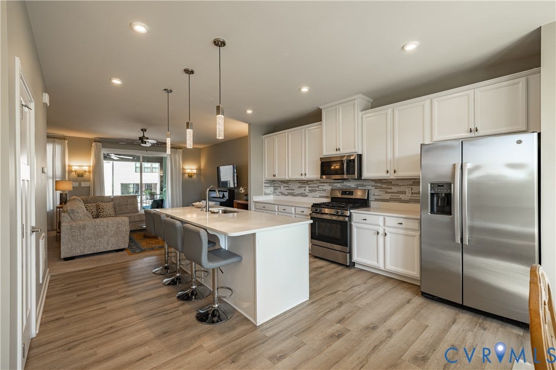 14336 Altavista Boulevard, Midlothian, VA 23114 Kitchen featuring stainless steel appliances, white cabinetry, a large center island with pendant lighting, and wood-finish flooring