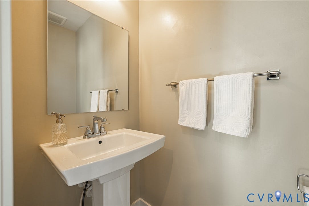 14336 Altavista Boulevard, Midlothian, VA 23114 Pedestal sink with chrome faucet, wall-mounted mirror, and wall-mounted towel bar