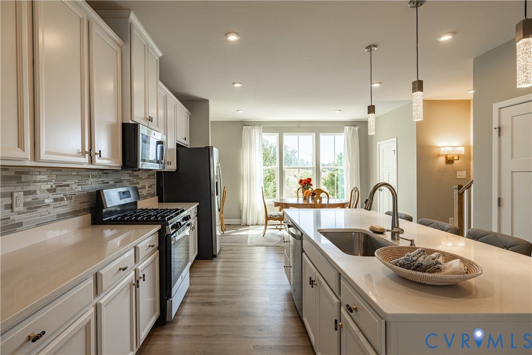 14336 Altavista Boulevard, Midlothian, VA 23114 Kitchen featuring white cabinetry, light-toned countertops, stainless steel appliances, and wood-finish flooring